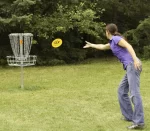 X-COM Disc-Golf - joueur qui lance un disque dans un panier - Boutique Frisbee-Ultimate